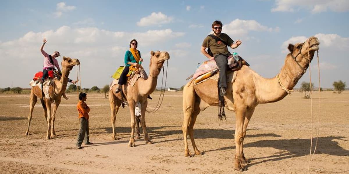 Tourists Enjoying Desert Camel Ride Safari Tour in Thar Desert Desert Camel Ride Safari Tour